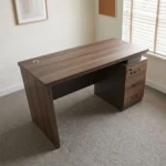 1.4m straight advanced table featuring a dark walnut wood-grain laminate finish, a circular cable management grommet on the tabletop, an integrated under-desk three-drawer lockable pedestal with curved black handles, a full modesty panel, and sturdy wooden side panel legs.