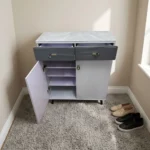Modern bucket flip shoe rack featuring a faux grey marble top surface, two top grey lockable drawers with gold pull handles, lower dual white hinged doors opening to multi-tiered shoe storage shelves, and elevated dark tapered wooden legs.