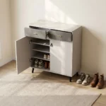 Modern bucket flip shoe rack featuring a faux grey marble top surface, two top grey lockable drawers with gold pull handles, lower dual white hinged doors opening to multi-tiered shoe storage shelves, and elevated dark tapered wooden legs.