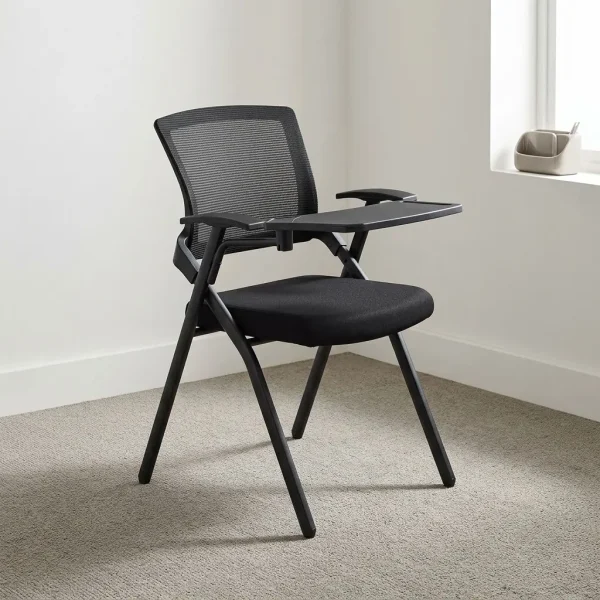 Modern foldable training chair featuring a breathable black mesh backrest, a cushioned black fabric flip-up seat pan, integrated armrests with a right-hand foldaway writing tablet tablet-arm, and a black powder-coated steel folding frame structure equipped with floor glides.