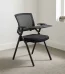 Modern foldable training chair featuring a breathable black mesh backrest, a cushioned black fabric flip-up seat pan, integrated armrests with a right-hand foldaway writing tablet tablet-arm, and a black powder-coated steel folding frame structure equipped with floor glides.